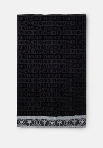 Écharpe noire avec motif répétitif du texte « Versace » et bordure décorative argentée ornée de motifs classiques le long d’un bord.