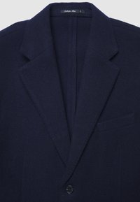 Dunkelblauer Wollblazer für Herren mit Reverskragen, einem einzigen schwarzen Knopf und einer Brusttasche auf der linken Seite.