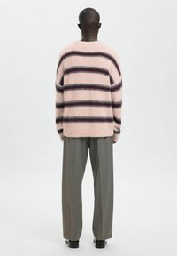 Roze en donker gestreepte trui met een ontspannen pasvorm, zachte textuur, ronde hals en afgezakte schouders, gecombineerd met grijze wijde pijpen broek.