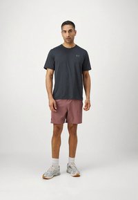 Hall triibuline lühikeste varrukatega särk koos heleroosade lühikeste pükstega. Omadusteks on hingav kangas, ümar kaelus ja spordijalatsid aktsentidega.