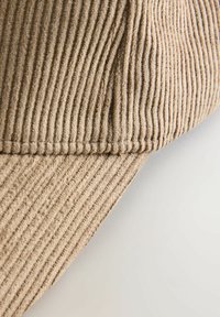 Brown corduroy cap with vertical ribbed texture, featuring a curved brim and stitched detailing along the edges.