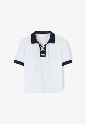 Wit shirt met korte mouwen, marineblauwe kraag en mouwranden, voorzien van een veterluiting aan de voorkant met metalen oogjes en witte aantrekkoorden.