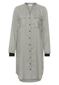 Abito a camicia a quadri bianco e nero con maniche lunghe, due tasche sul petto, chiusura con bottoni e polsini neri a coste. Texture del tessuto liscia.