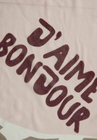 Baumwollstoff mit einem hellrosa Hintergrund, auf dem in dunkelbrauner, handgezeichneter Schrift "J'aime Bonjour" in einer verspielten Schriftart zu lesen ist.