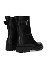 Botas de tobillo de cuero negro con una textura suave, que presentan un detalle de hebilla en el costado y una suela de goma gruesa. La marca es visible en el tacón.