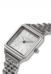 Silver rektangulär armbandsklocka med metallänkband, minimala urtavlemarkörer, tre visare och "Copenhagen Studios" logotyp på urtavlan.