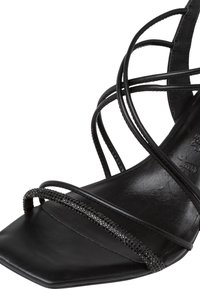Black strappy sandal with a square toe, featuring sleek leather material and a decorative rhinestone accent along the straps.