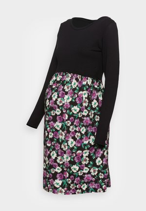 Vestido premamá negro de manga larga con escote redondo y falda hasta la rodilla con un estampado floral en púrpura y blanco.