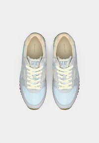 Γαλάζια και μπεζ αθλητικά παπούτσια GANT με λευκά κορδόνια, σε θέα από πάνω, σε λευκό απλό φόντο.