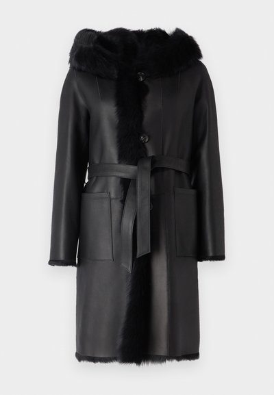Μαύρο δερμάτινο παλτό με κουκούλα από συνθετική γούνα, κλείσιμο με κουμπιά και ζώνη. Διαθέτει δύο μπροστινές τσέπες και απαλή υφή στα άκρα.