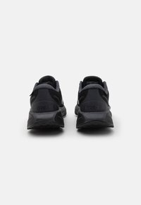 Sorte GORE-TEX terrengløpesko med mesh-overdel, polstret krage og gummisåle. Hæltab og merkevaredetalj på siden.