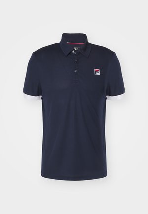 Camisa polo en color navy hecha de tela transpirable, con cuello tipo polo, tres botones y puños en blanco. Presenta un pequeño logo en el pecho.