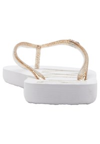 Gyllene glittrande flip-flop med en tunn rem och en vit sula, som har en texturerad yta och subtil logodetalj på fotbädden.
