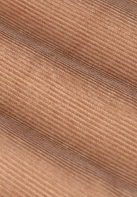 Tissu en velours côtelé rose poussiéreux avec de fines côtes verticales, texture lisse et éclat subtil, mettant en valeur des sous-tons chaleureux et un motif régulier.