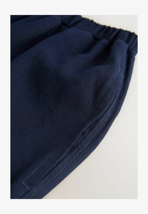 Mörkblå tygshorts med elastisk midja, med en slät textur och kontrasterande sömnadsdetaljer längs sidsömmarna.