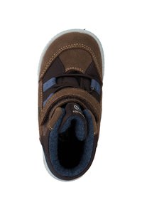 Brauner Wildlederstiefel mit dunkelblauen Akzenten, ausgestattet mit einem Klettverschlussriemen und gepolstertem Schaft. Gummisohle mit weißem Profil für besseren Halt.