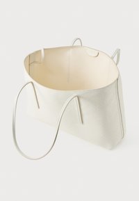 Grote off-white totebag met dunne schouderbanden, open bovenkant en subtiel diamantpatroon aan de buitenkant, weergegeven tegen een witte achtergrond.