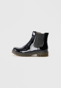 Bottines en cuir verni noir avec des accents en tissu élastique sur les côtés, bout rond et semelle en caoutchouc texturé.