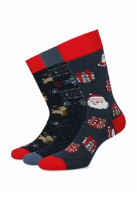 Trzy pary ciemnych skarpet z świątecznymi wzorami: czerwone akcenty, Święty Mikołaj, płatki śniegu i prezenty; różne wzory i faktury. 