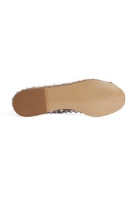 Chaussures avec une semelle en caoutchouc beige texturé, au surface lisse et petits points surélevés le long du bord. Détails de traction anti-dérapants inclus.