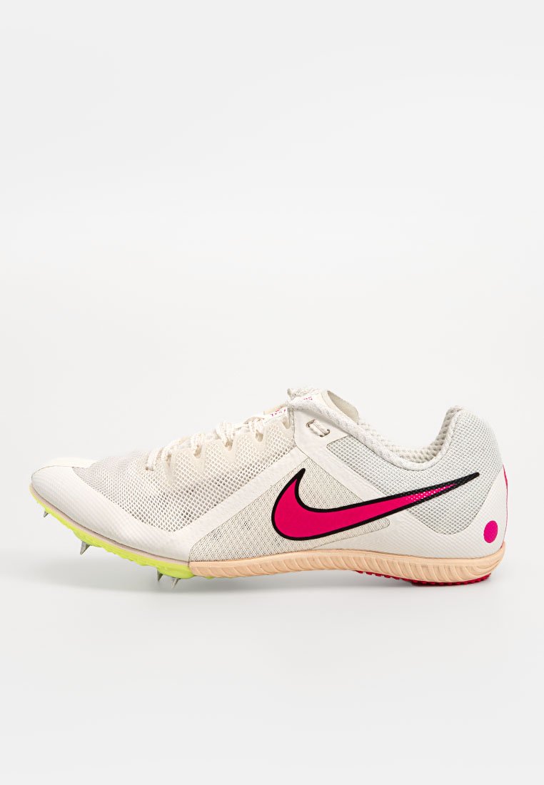 Lightweight, cream-colored athletic shoe with mesh upper, pink Nike logo, and spike outsole. Features accent colors of black and neon yellow.
