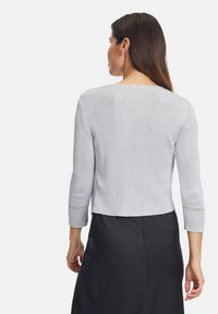 Maglione grigio chiaro cropped con maniche a tre quarti, tessuto testurizzato, leggero luccichio e dettagli in pizzo ai orli delle maniche.