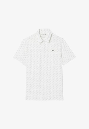 Camisa polo blanca hecha de tejido transpirable, con un patrón repetitivo de marcas de verificación verdes y un logotipo verde bordado en el pecho.