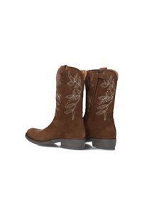 Bruine suede laarzen tot de kuit met witte bladopdruk, lage hakken, ritssluitingen aan de zijkant en lussen op een witte achtergrond.