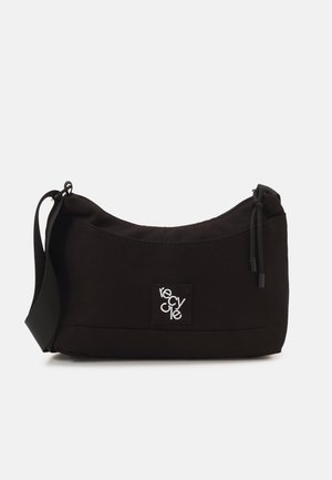 Sort skuldertaske med afrundet form, stoffmateriale, justerbar rem og et frontpatch med teksten "recycle" i hvid.