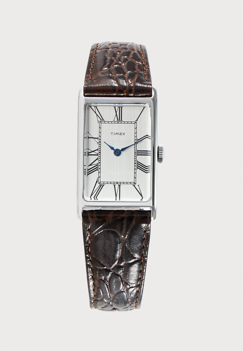 Правоъгълен сребърен часовник Timex с бял циферблат, сини стрелки за час и минута, черни римски цифри и текстуриран каишка от тъмнокафява кожа.