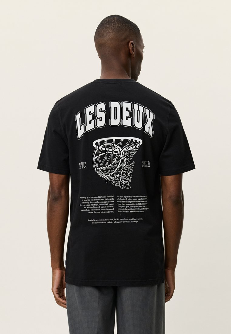 Μαύρο βαμβακερό t-shirt με μεγάλο λευκό κείμενο στην πλάτη, γραφικό με μπασκετικό καλάθι και εκτυπωμένο κείμενο με περιγραφικές λεπτομέρειες.