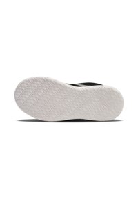 Schwarzer Sportschuh mit einer strukturierten schwarzen Oberseite und einer weißen Gummisohle, die ein geometrisches Traktionsmuster aufweist. Markenlogo auf der Sohle.