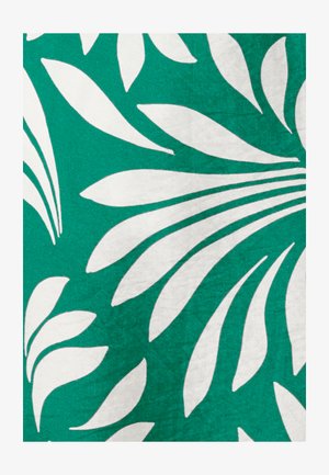 Motifs de feuilles tropicales blanches sur un fond de tissu vert vif, montrant un dessin botanique audacieux et abstrait.
