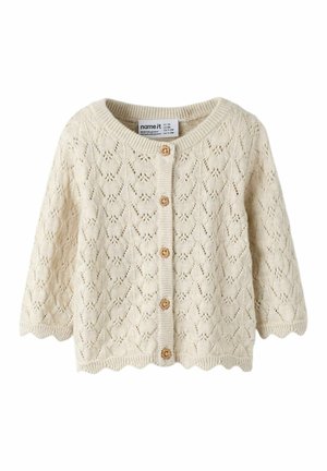 Kremowy, dziergany sweterek niemowlęcy z falistymi krawędziami, drewnianymi guzikami i koronkowym wzorem w kształcie diamentu.