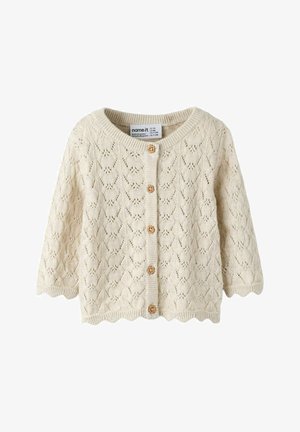 Crèmekleurige gebreide babycardigan met geschulpte randen, houten knopen en een kantachtig diamantpatroon.