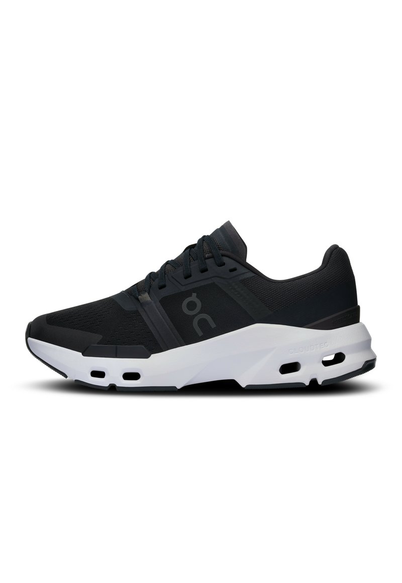 Scarpe da ginnastica nere con tomaia in rete traspirante, suola in gomma e dettagli bianchi. Presentano un design imbottito e di supporto con fori di ventilazione visibili.