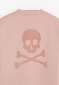 Lyserød stof med et glitrende kranie og korsede knogler design centreret under en ribbede halsudskæring.