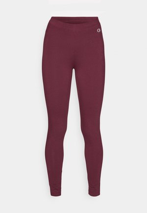 Burgundia legginsid, mis on valmistatud venivast kangast, omavad siledat tekstuuri ja laia vööd. Ülemisel vasakul küljel on nähtav väike logo.