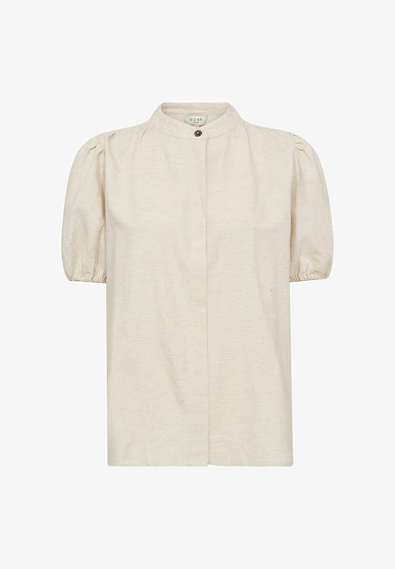 Blusa corta a maniche corte color crema con colletto alto, chiusura a bottoni e maniche a sbuffo arricciate. Realizzata in un tessuto testurizzato con leggere impronte.