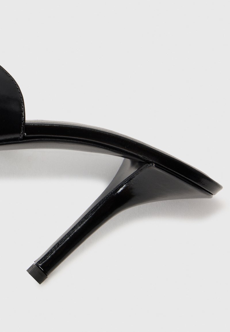 Schwarze High-Heels-Sandaletten mit glatter Oberfläche, offenen Zehenspitzen, schlankem Stiletto-Absatz und minimalistischer Riemchenverzierung.