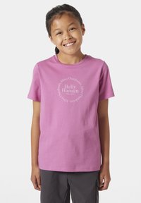 Růžové bavlněné tričko krátkým rukávem, s kulatým bílým grafickým potiskem "Helly Hansen" a textem. Jednoduchý design, kulatý výstřih.
