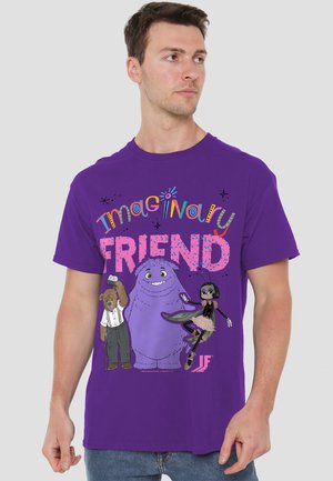 Purple t-shirt featuring cartoon characters. Design includes a bear, a purple creature, and a girl in a tutu. Text reads "Imaginary FRIEND" in colorful fonts.