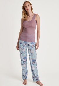 Lichtpaars camisole met kantafwerking, gecombineerd met blauwe bloempatronen pyjamabroek met een verscheidenheid aan bloemen en vogels in een zachte, lichte stof.