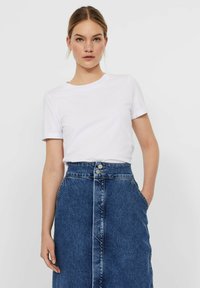 White short-sleeve t-shirt paired with a blue denim skirt featuring front buttons and side pockets, showcasing a classic casual design.