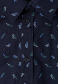Chemise bleu marine avec un petit motif abstrait de coups de pinceau en vert, bleu et gris, avec des boutons noirs et un col pointu.