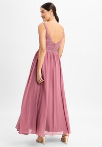 Langes pinkes Kleid mit tiefem V-Rücken und verstellbaren Trägern, mit bestickten Details am Oberteil und einem fließenden, mehrlagigen Rock.