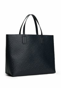 Zwarte tote bag gemaakt van gestructureerd synthetisch materiaal, met geometrische patronen, stevige dubbele handvatten en een open-top ontwerp.