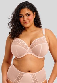 Ljusrosa bh med meshpaneler och dekorativa prickdetaljer. Underwire-formen ger stöd. Har justerbara axelband och slät teknik.