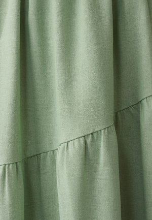 Helles grünes Strukturgewebe mit gerafften Rüschen, das eine glatte Oberfläche und ein dezentes Webmuster aufweist, ideal für Bekleidung oder Wohnkultur.