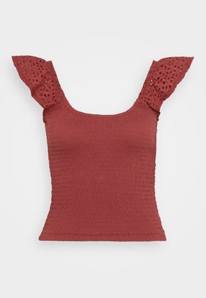 Rød smocket topp med korte ermer med blonderdetaljer. Har firkantet utringning og en tettsittende silhuett, som fremhever et strukturert stoff.